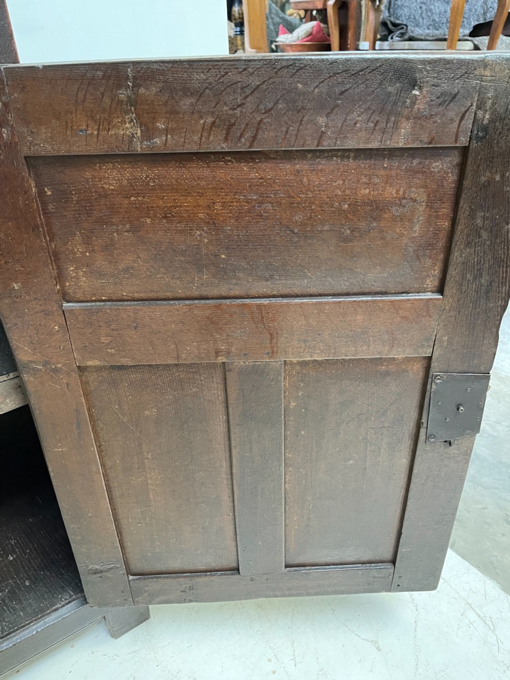 A dark carved oak court cupboard featuring upper and lower double doors with geometric diamond panels, guilloche frieze carving, and turned side supports. View X