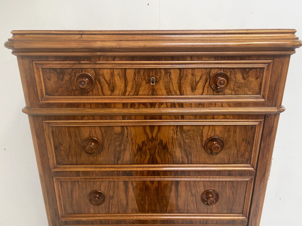 A tall Victorian walnut Wellington chest with seven graduated drawers, turned wooden knobs, and a hinged side-locking bar. View II