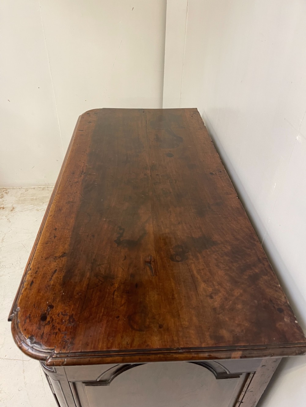 An antique French walnut buffet featuring two top drawers above two moulded panel cupboard doors with iron hardware and a solid plinth base. View IV