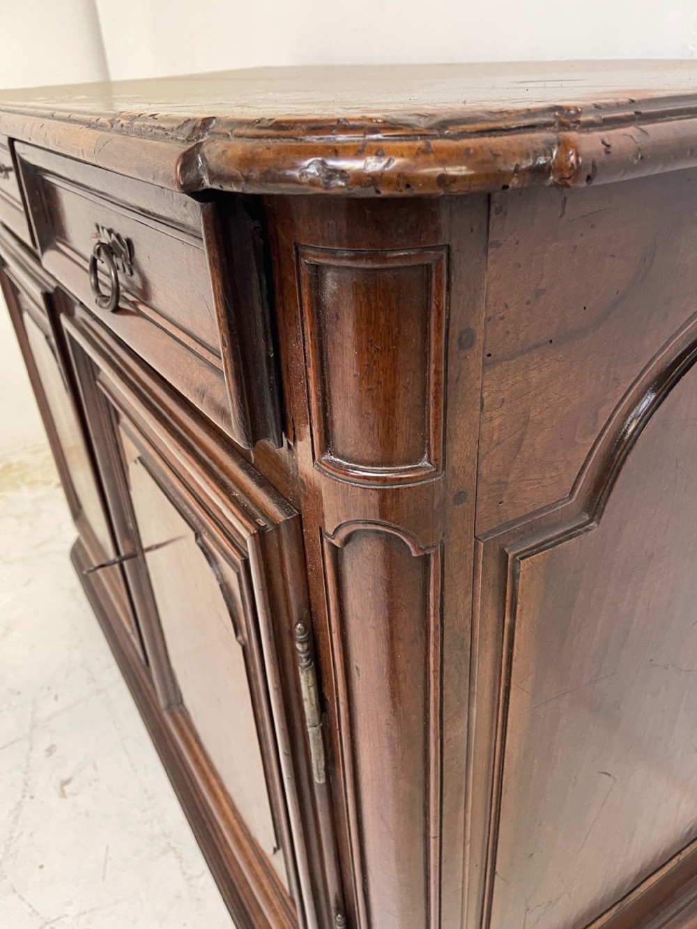An antique French walnut buffet featuring two top drawers above two moulded panel cupboard doors with iron hardware and a solid plinth base. View V