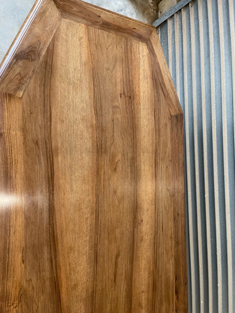 A long French walnut dining table featuring a shaped top with framed grain panels, turned legs, and a sculpted cross-stretcher. View VI