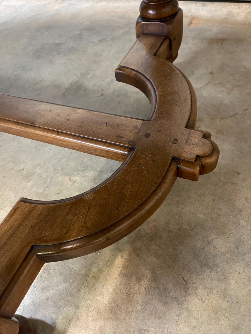A long French walnut dining table featuring a shaped top with framed grain panels, turned legs, and a sculpted cross-stretcher. View VIII
