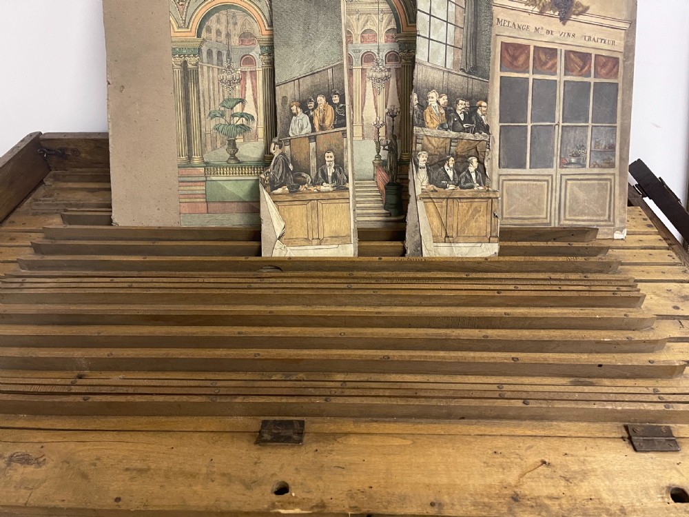 An antique wooden and paper toy puppet theatre labelled Opera, featuring miniature costumed marionettes on a painted classical stage. View XXI