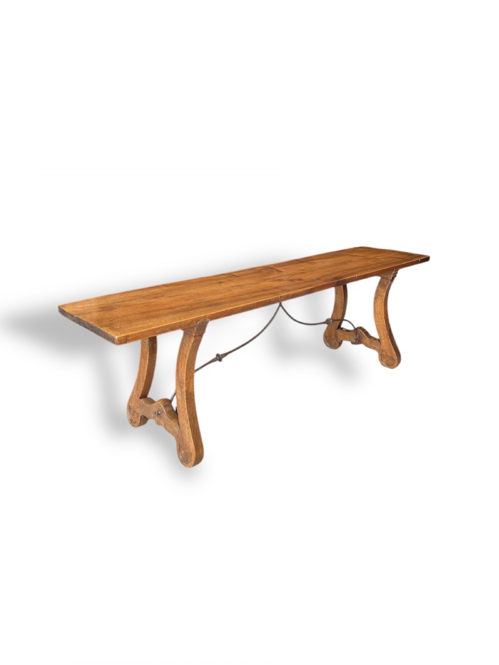 An antique French walnut serving table with a narrow rectangular top, curved trestle legs, and a wrought iron stretcher.