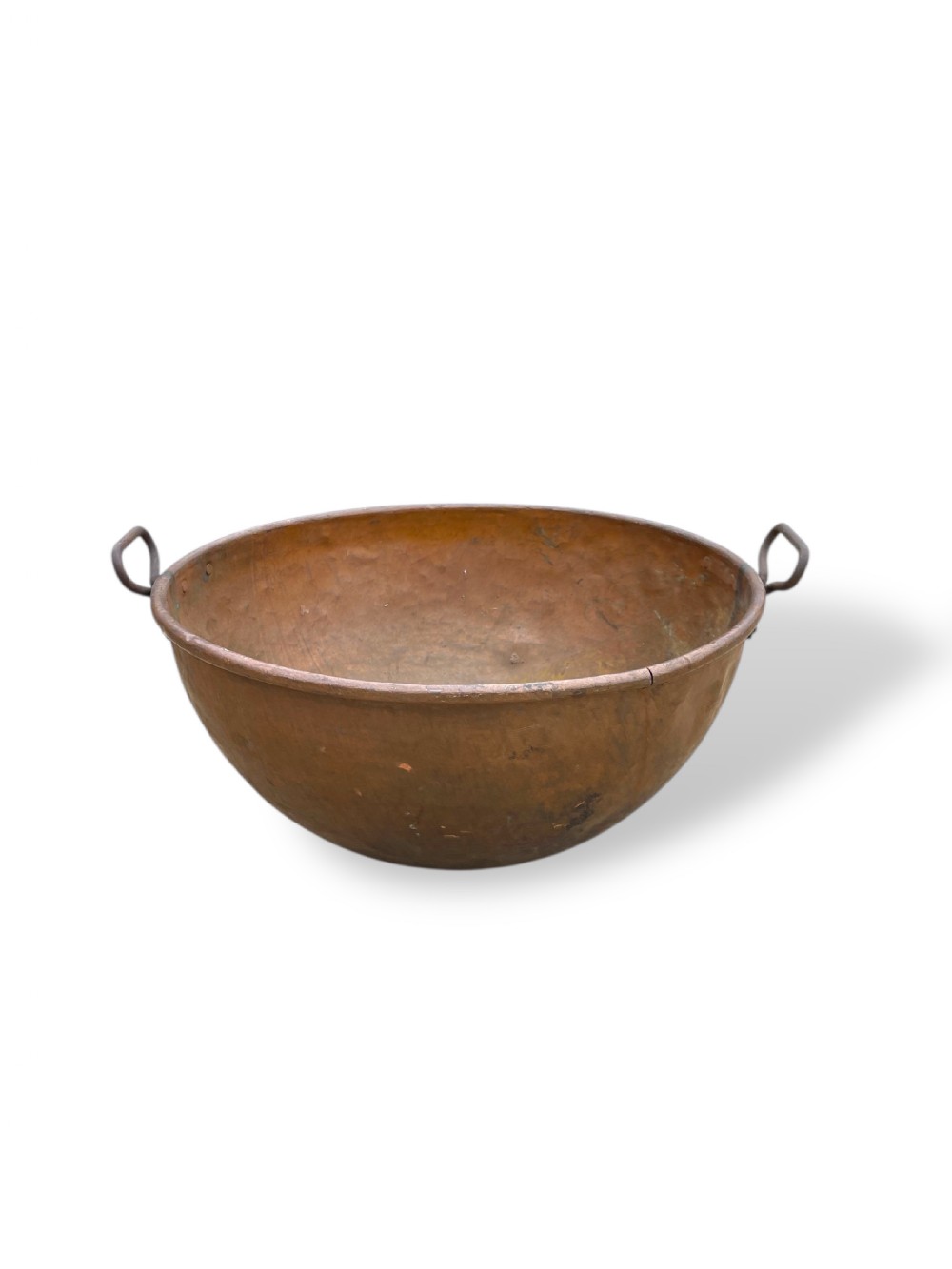 A large nineteenth-century hand-hammered copper bowl with rolled rim edges and two side loop handles.