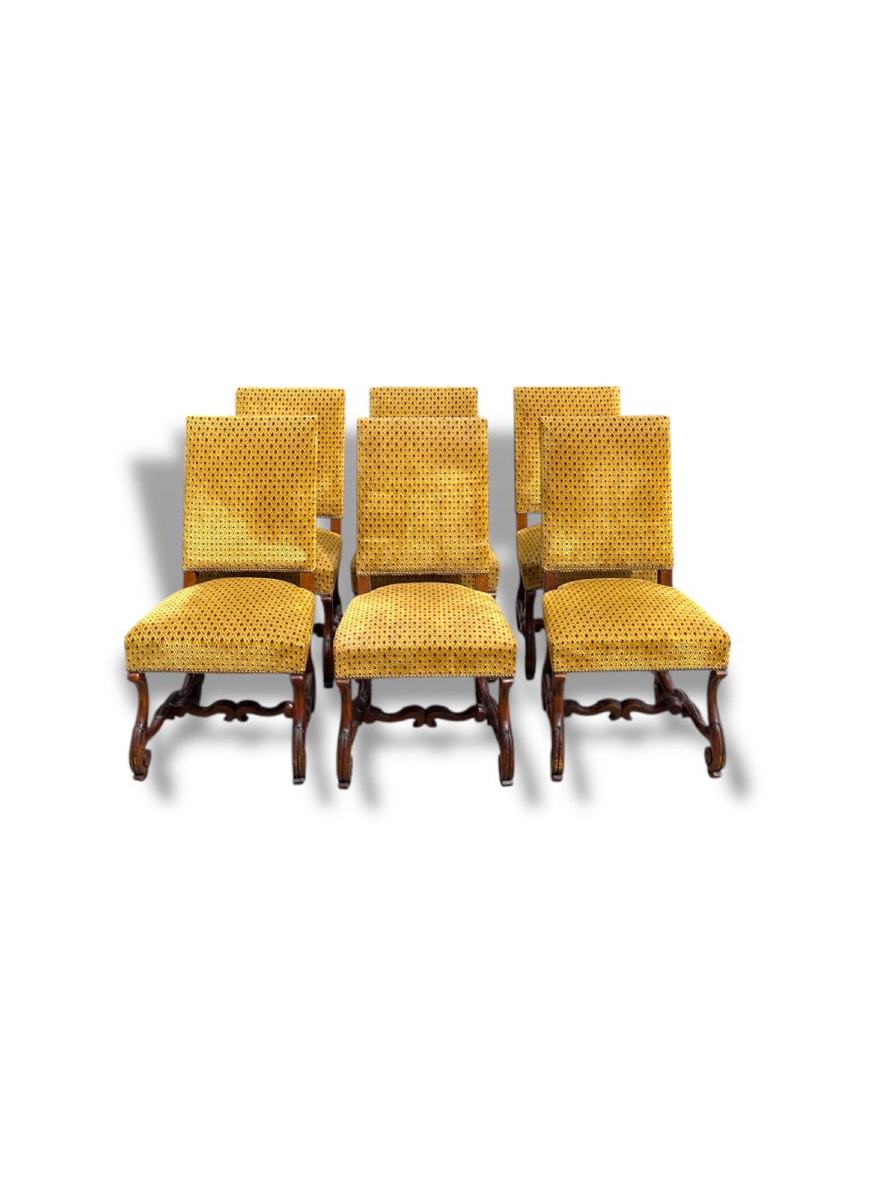 A set of six French walnut dining chairs upholstered in gold patterned fabric with carved wooden legs and stretchers.