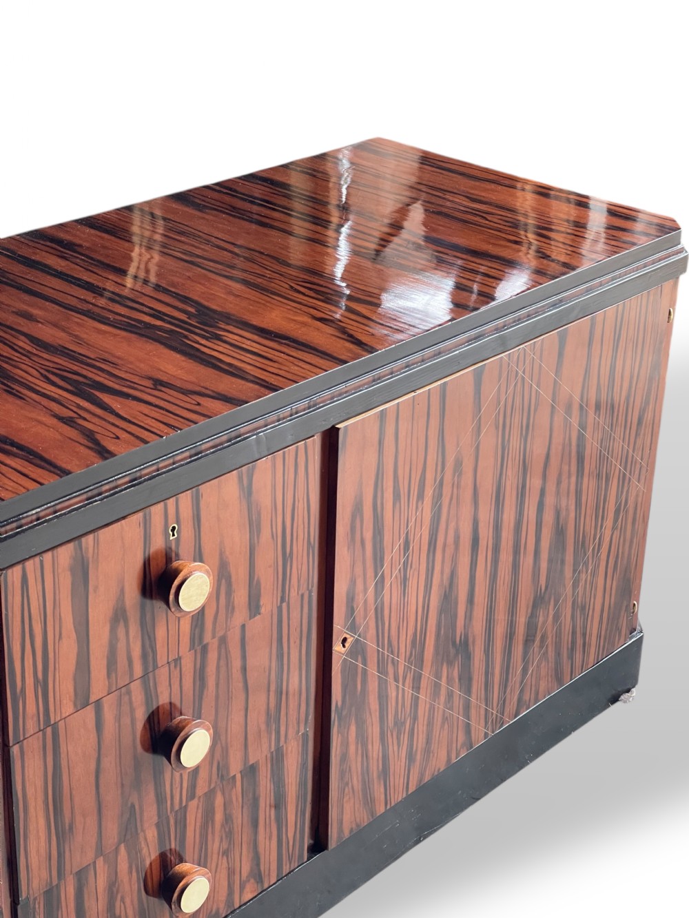 A low-profile French Art Deco sideboard in high-gloss Macassar ebony veneer with central drawers and geometric side door details. View VI
