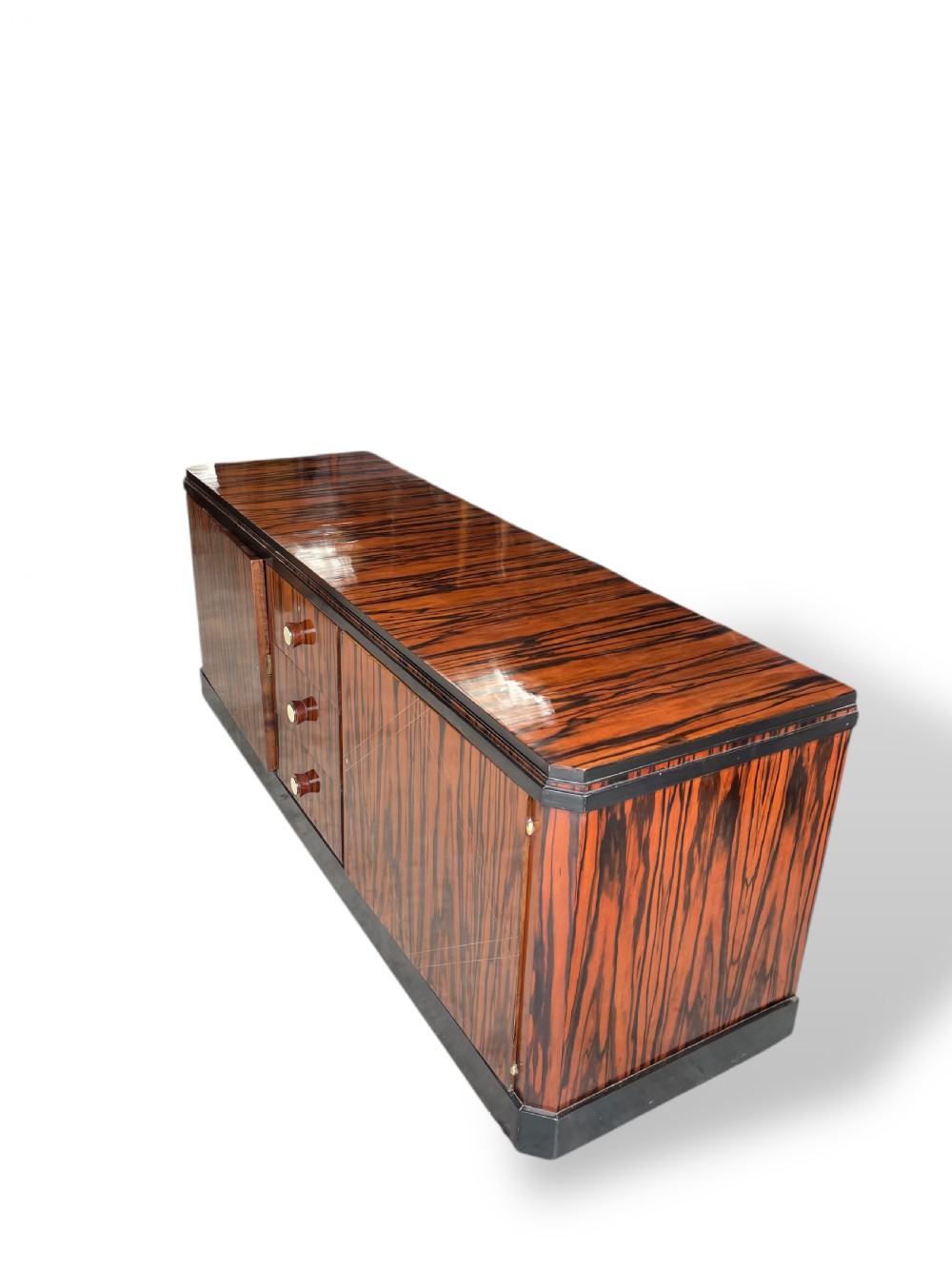 A low-profile French Art Deco sideboard in high-gloss Macassar ebony veneer with central drawers and geometric side door details. View X