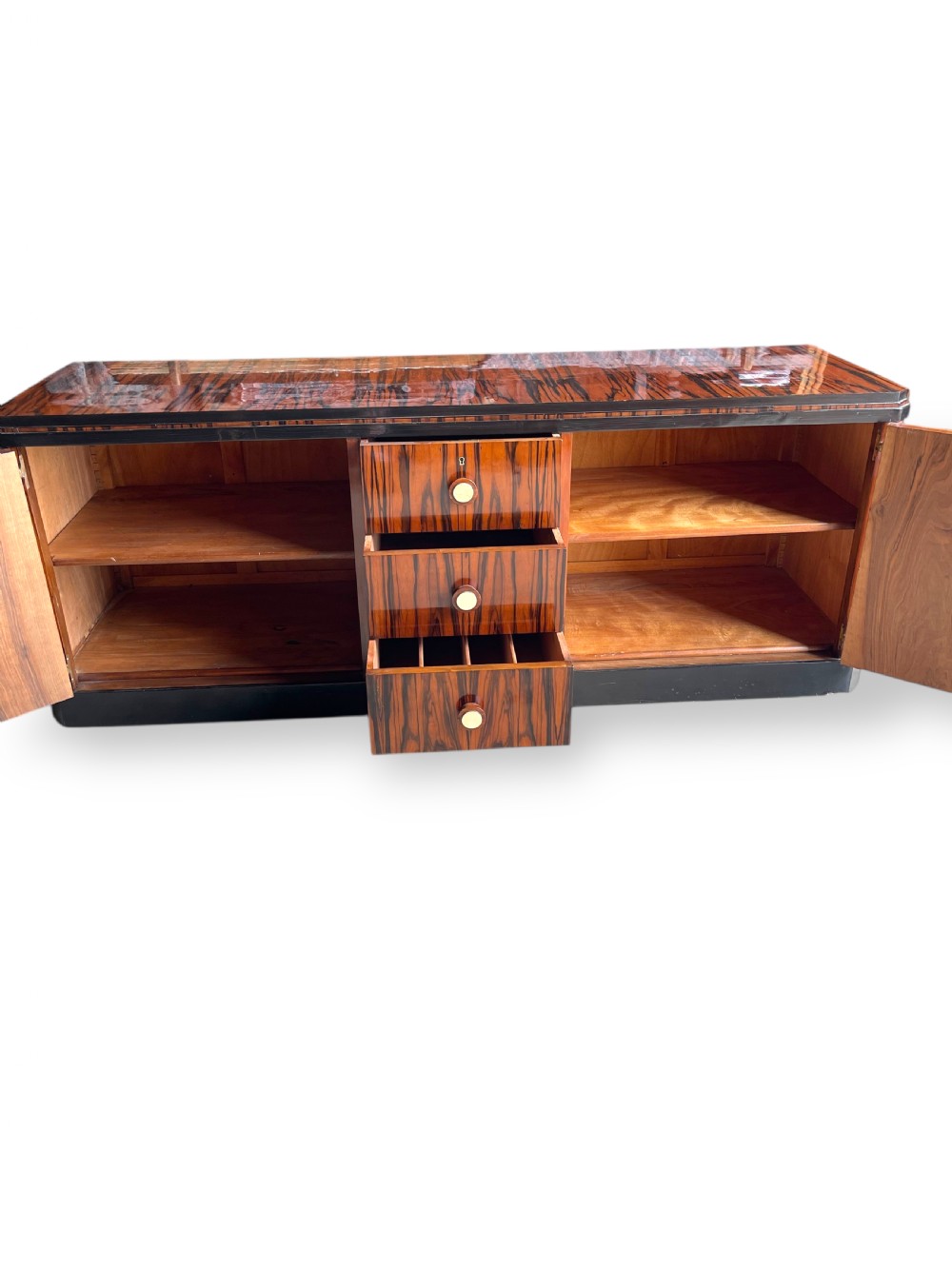A low-profile French Art Deco sideboard in high-gloss Macassar ebony veneer with central drawers and geometric side door details. View XII