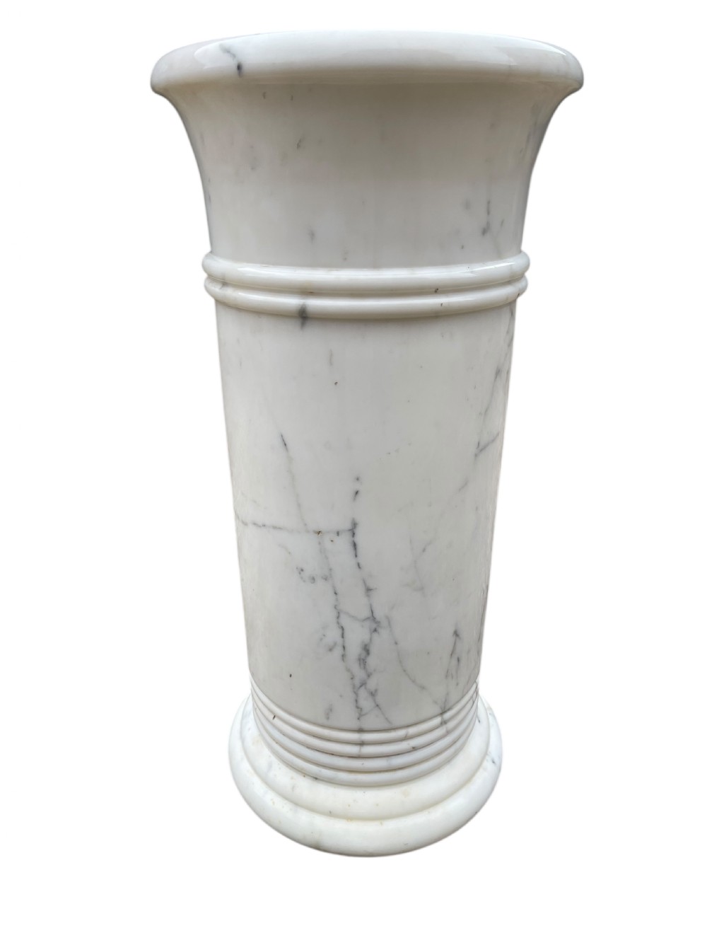 A cylindrical white marble umbrella stand with grey veining, flared rim, and reeded banding details. View IV
