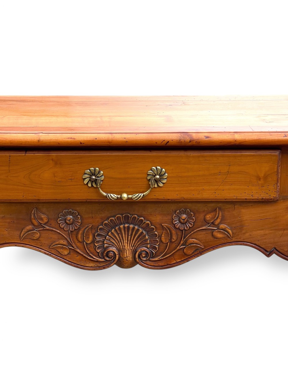 A French provincial cherrywood serving table featuring three drawers with brass drop handles, a hand-carved central shell motif on the apron, and slender cabriole legs. View VIII