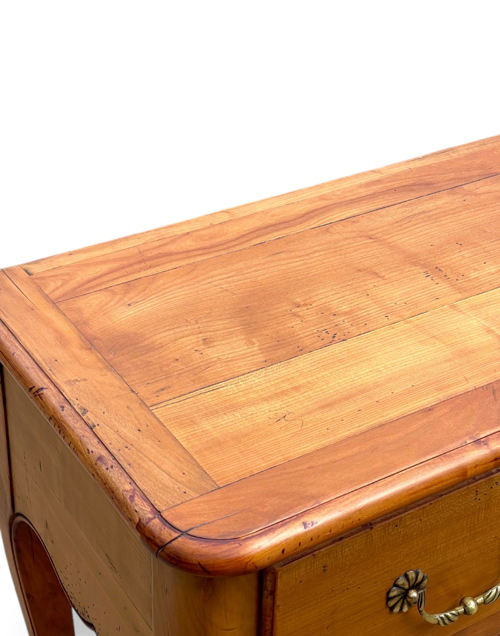 A French provincial cherrywood serving table featuring three drawers with brass drop handles, a hand-carved central shell motif on the apron, and slender cabriole legs. View IX