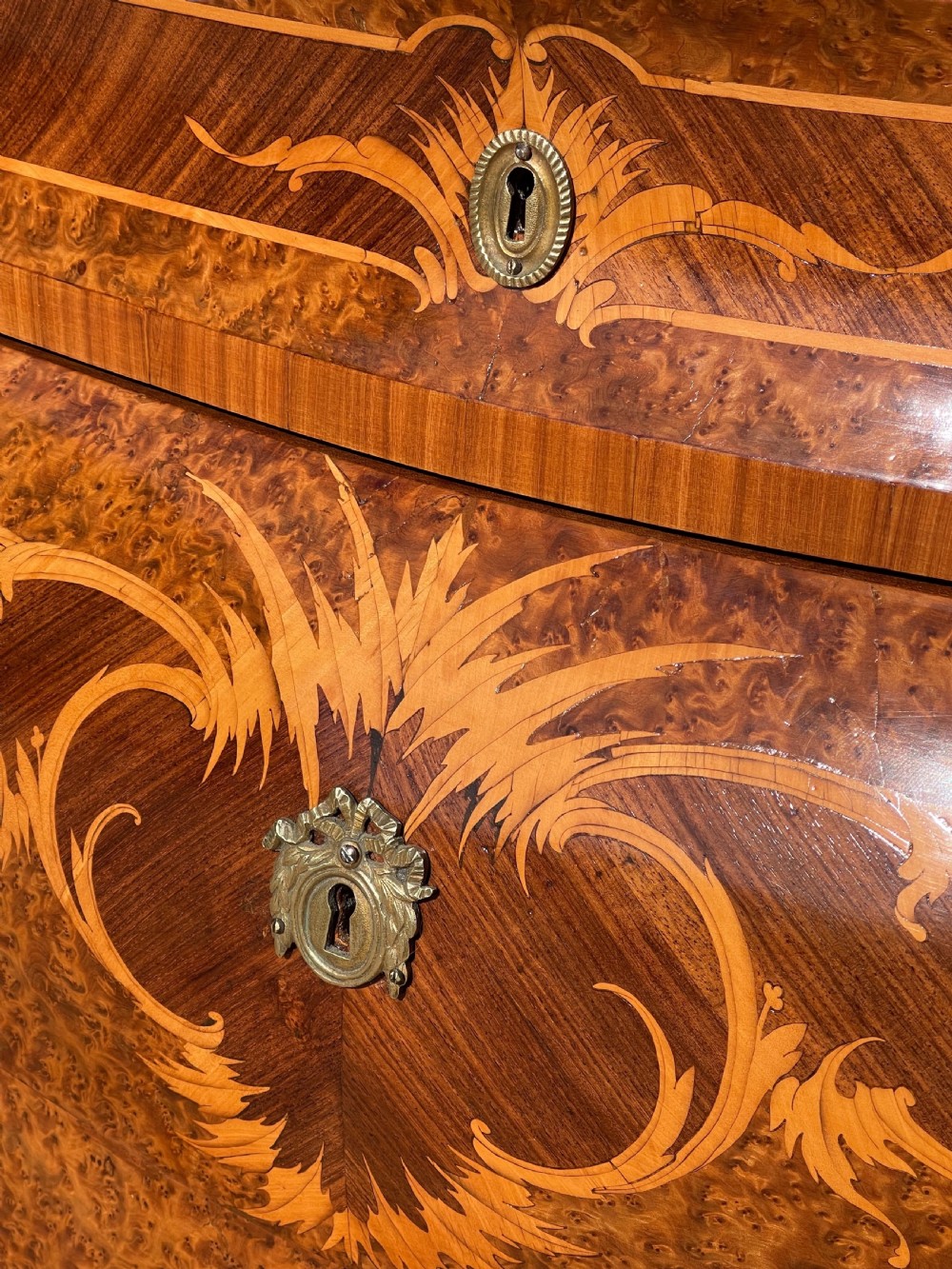 A pair of Italian bombe commodes featuring intricate floral marquetry timber inlays, dark green marble tops, and brass handles. View XII