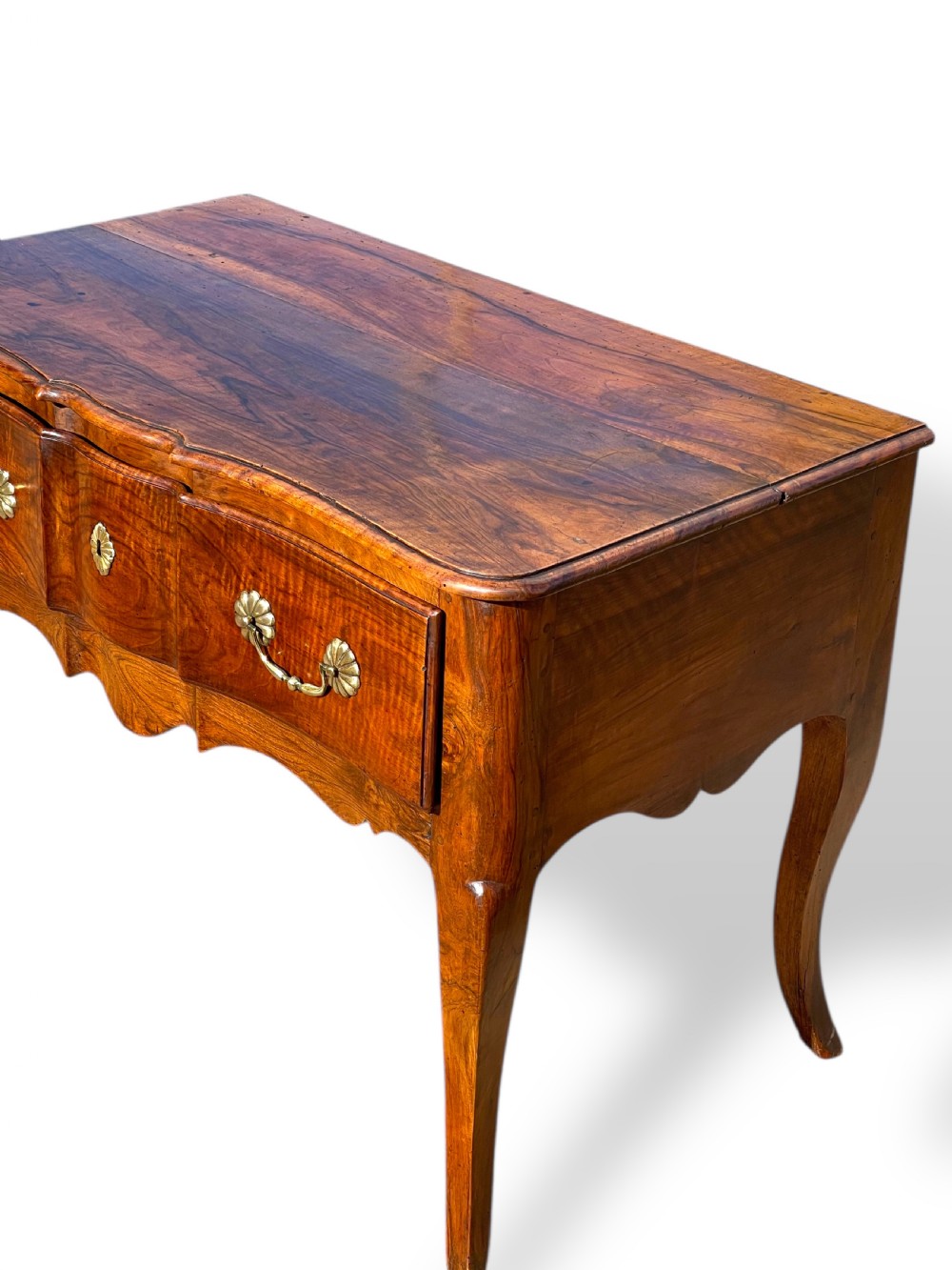 An 18th-century French walnut side table featuring a contoured serpentine front, single drawer with decorative brass handles, a shaped apron, and curved cabriole legs. View VIII