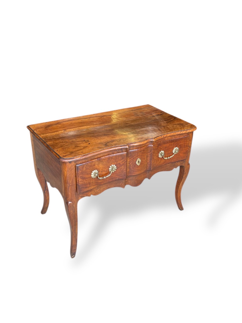 An 18th-century French walnut side table featuring a contoured serpentine front, single drawer with decorative brass handles, a shaped apron, and curved cabriole legs. View X