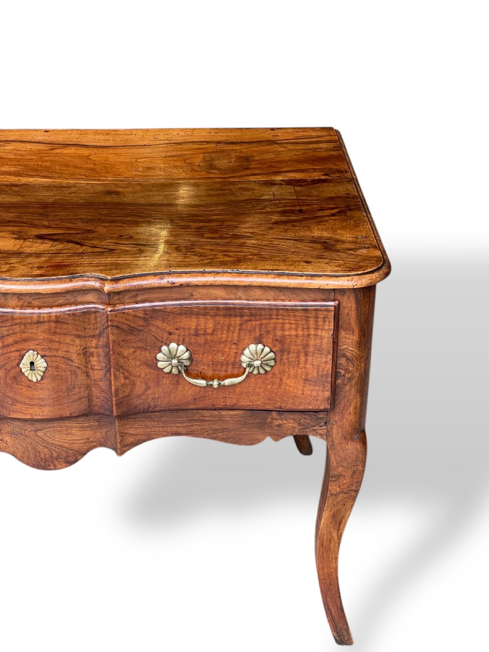 An 18th-century French walnut side table featuring a contoured serpentine front, single drawer with decorative brass handles, a shaped apron, and curved cabriole legs. View XI