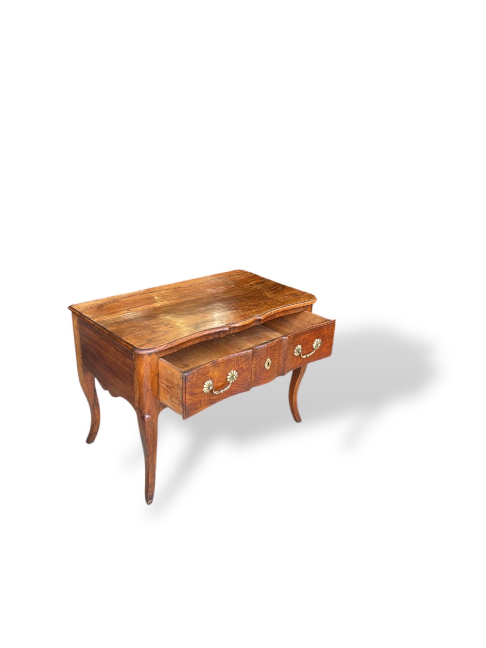 An 18th-century French walnut side table featuring a contoured serpentine front, single drawer with decorative brass handles, a shaped apron, and curved cabriole legs. View XVI