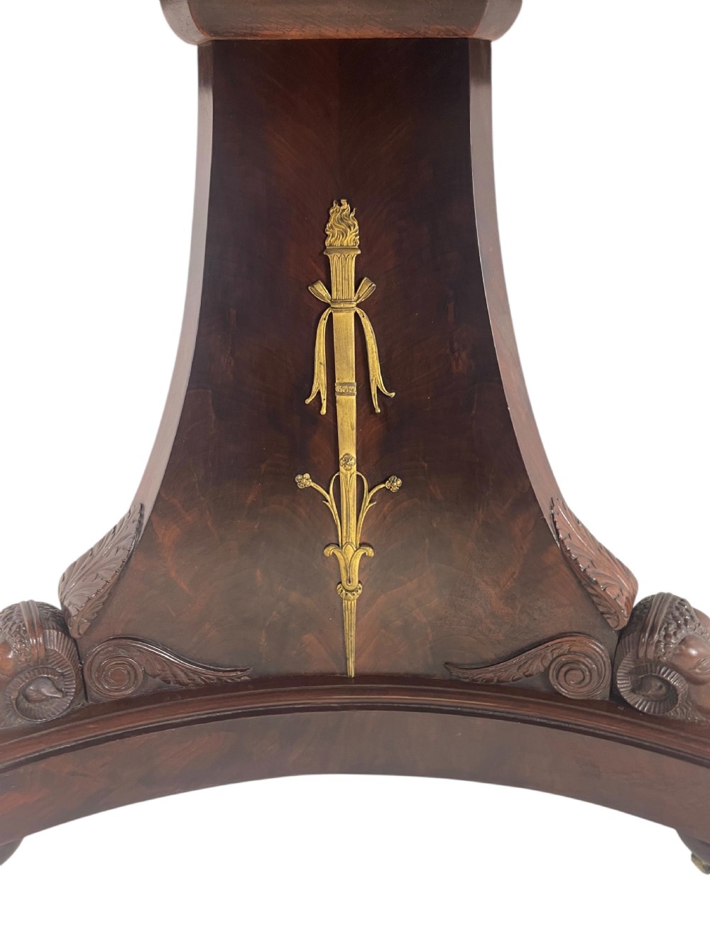 An early nineteenth-century French Empire gueridon table with a circular grey veined marble top resting on a mahogany base with carved ram heads. View VI