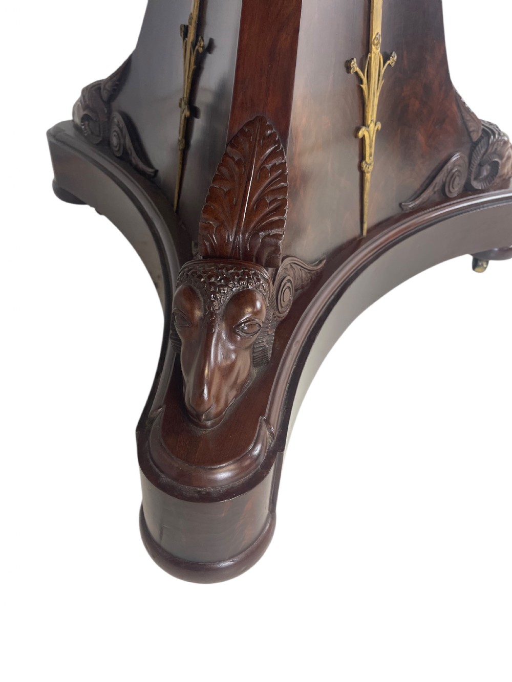 An early nineteenth-century French Empire gueridon table with a circular grey veined marble top resting on a mahogany base with carved ram heads. View VII