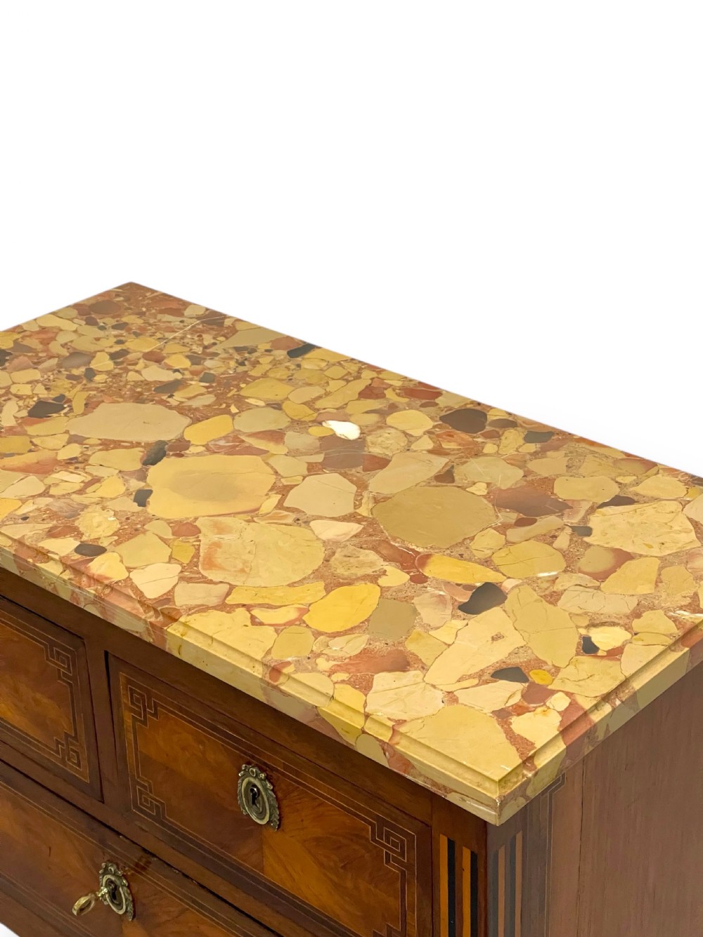 A Louis XVI style wooden commode featuring geometric parquetry inlay, a variegated marble top, three drawers with brass escutcheons, and tapered square legs. View VI