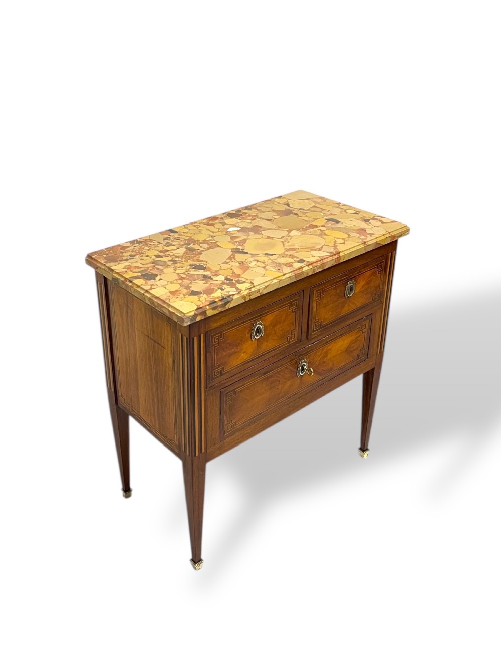 A Louis XVI style wooden commode featuring geometric parquetry inlay, a variegated marble top, three drawers with brass escutcheons, and tapered square legs. View XII
