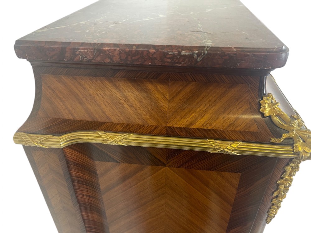 A French Louis XV style marquetry cabinet featuring geometric veneer panelling, gilt-bronze corner mounts, and a dark marble top. View II