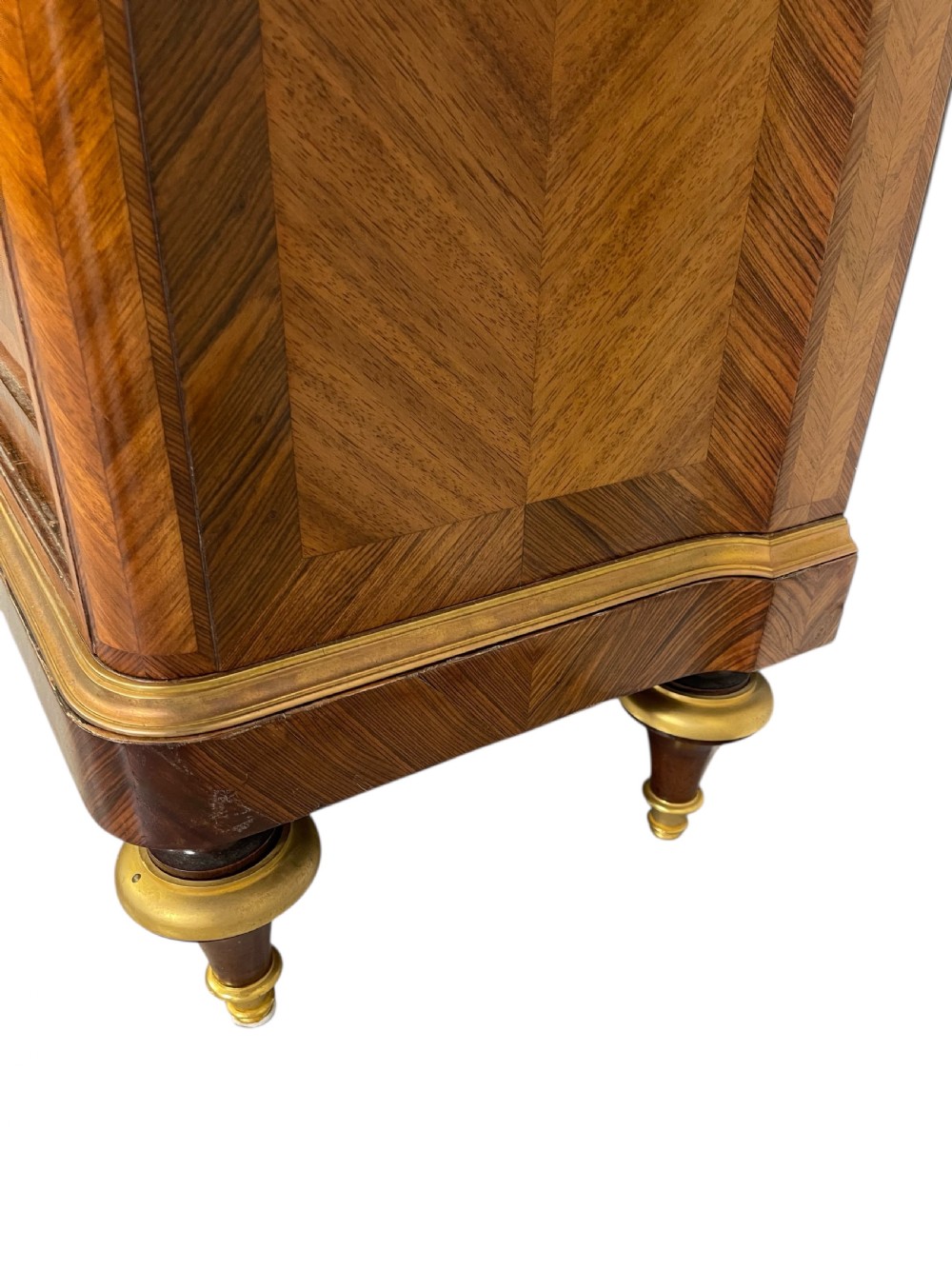 A French Louis XV style marquetry cabinet featuring geometric veneer panelling, gilt-bronze corner mounts, and a dark marble top. View XI
