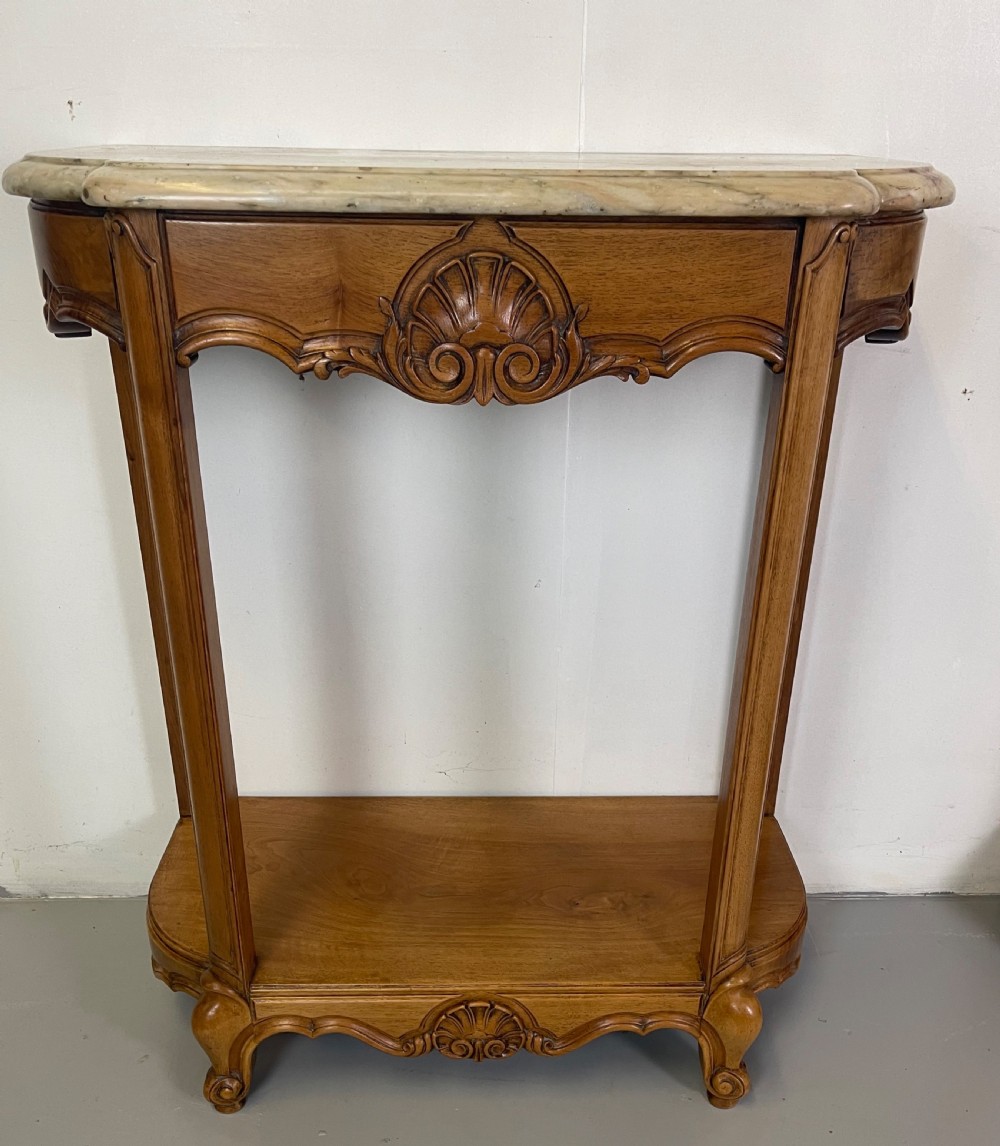 A pair of French Louis XV style walnut console tables featuring shaped marble tops, carved shell aprons, lower shelves, and cabriole legs. View II