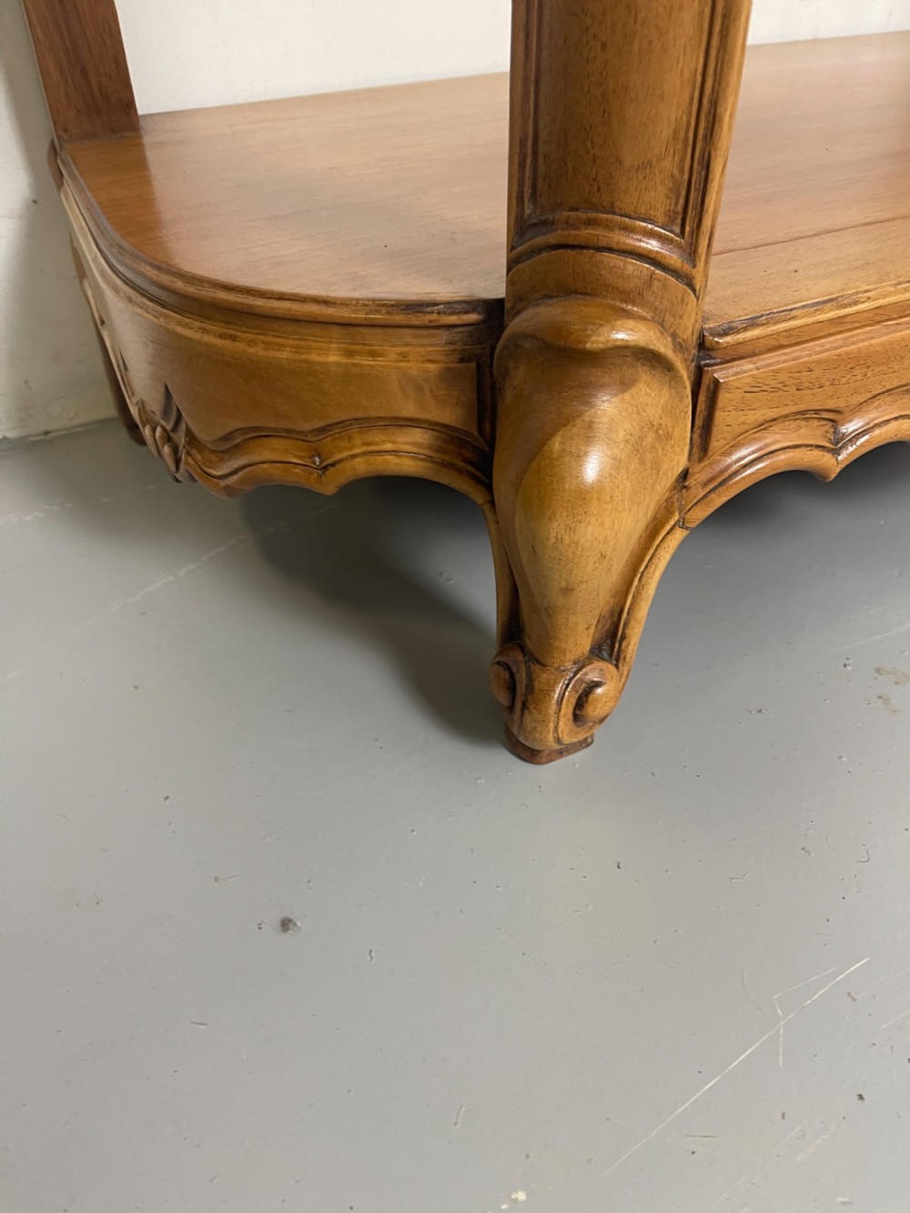 A pair of French Louis XV style walnut console tables featuring shaped marble tops, carved shell aprons, lower shelves, and cabriole legs. View VIII