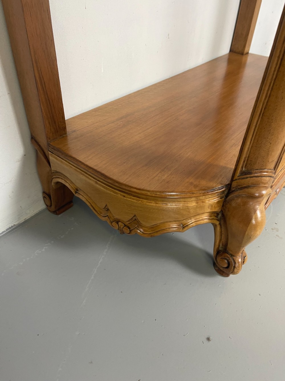 A pair of French Louis XV style walnut console tables featuring shaped marble tops, carved shell aprons, lower shelves, and cabriole legs. View IX
