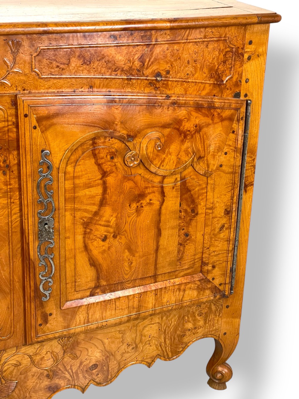 A French burr elm provincial dresser featuring two panelled doors with intricate grain patterns, steel escutcheons, a carved apron, and cabriole legs. View IV