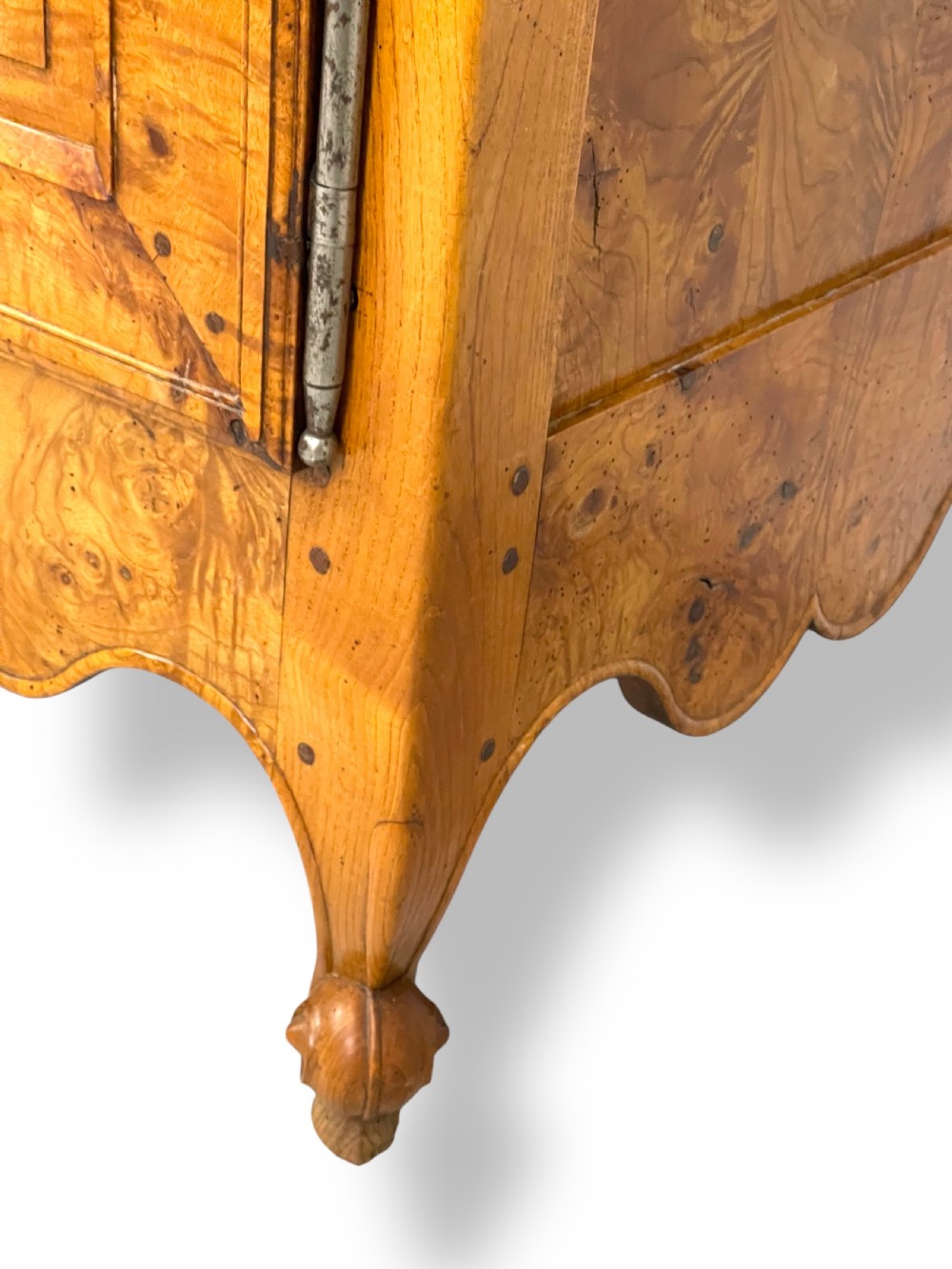 A French burr elm provincial dresser featuring two panelled doors with intricate grain patterns, steel escutcheons, a carved apron, and cabriole legs. View X