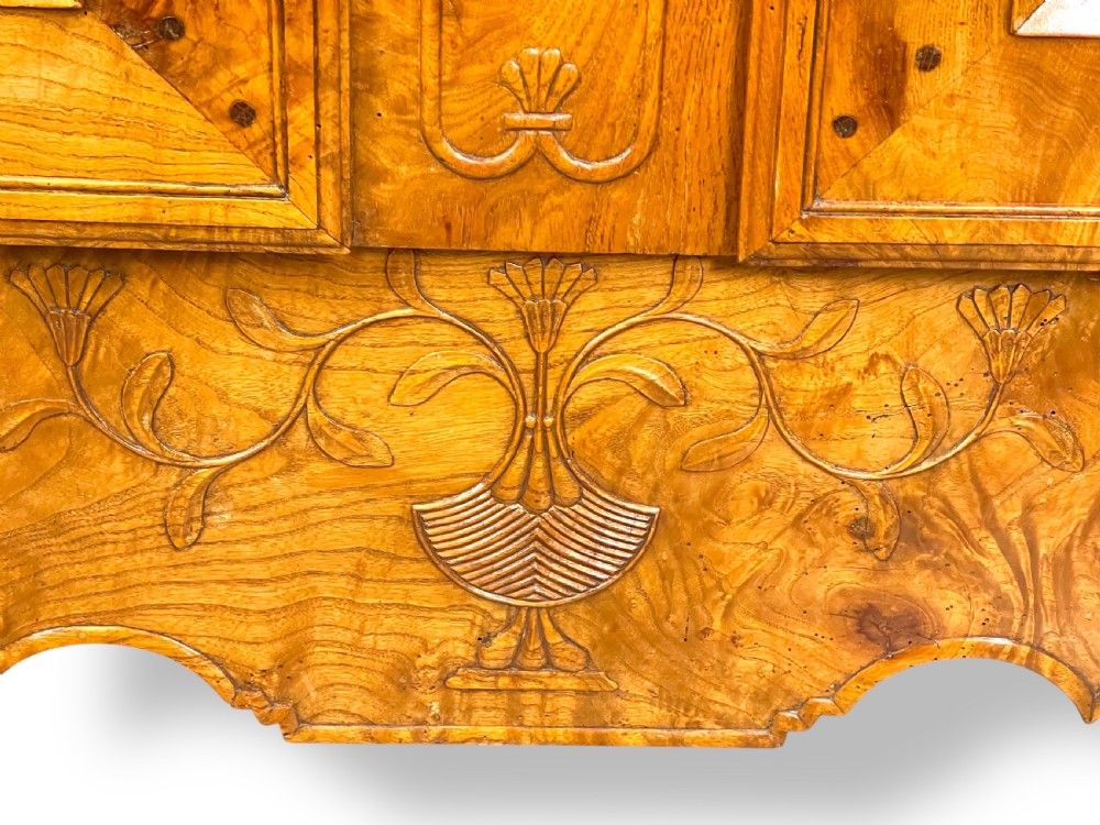 A French burr elm provincial dresser featuring two panelled doors with intricate grain patterns, steel escutcheons, a carved apron, and cabriole legs. View XI