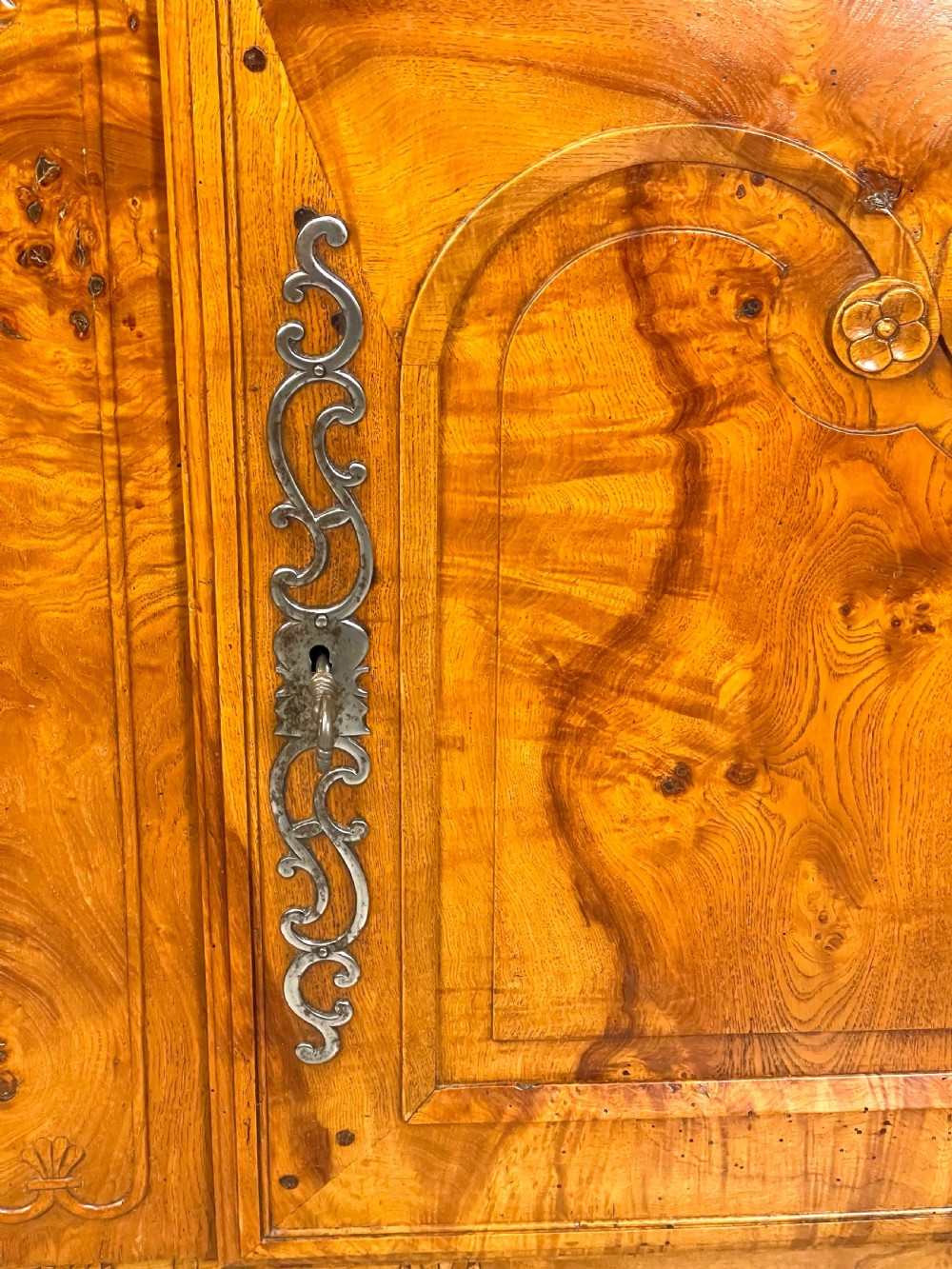 A French burr elm provincial dresser featuring two panelled doors with intricate grain patterns, steel escutcheons, a carved apron, and cabriole legs. View XII