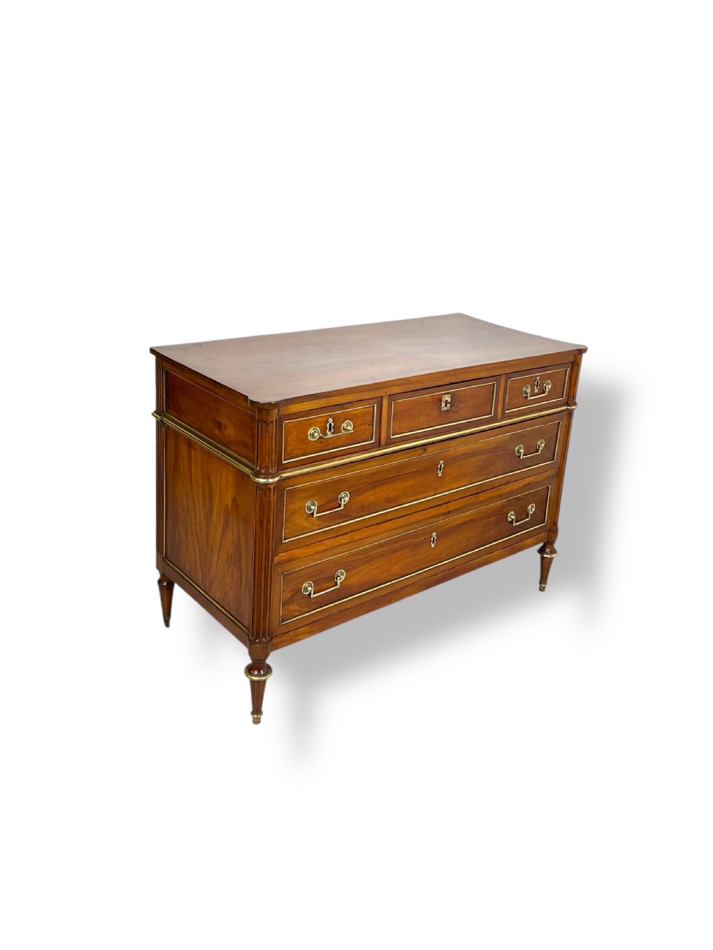 An eighteenth-century French walnut commode featuring three short upper drawers above two long drawers, detailed with brass mouldings and tapered legs.