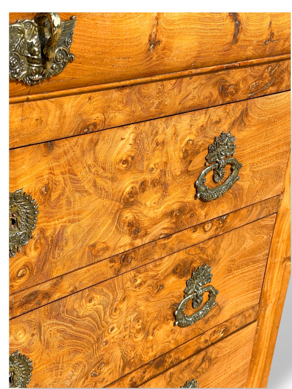 A French Louis Philippe style burr ash commode featuring a dark grey marble top, four drawers, and ornate brass handles. View VII