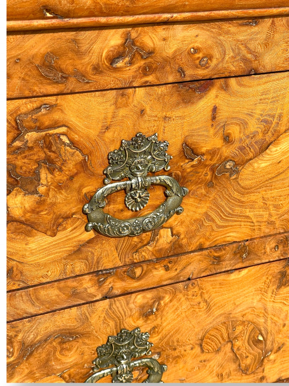 A French Louis Philippe style burr ash commode featuring a dark grey marble top, four drawers, and ornate brass handles. View VIII