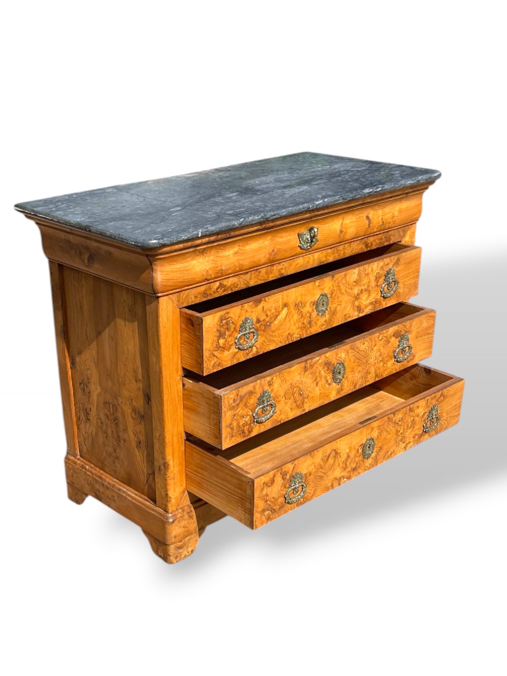 A French Louis Philippe style burr ash commode featuring a dark grey marble top, four drawers, and ornate brass handles. View IX