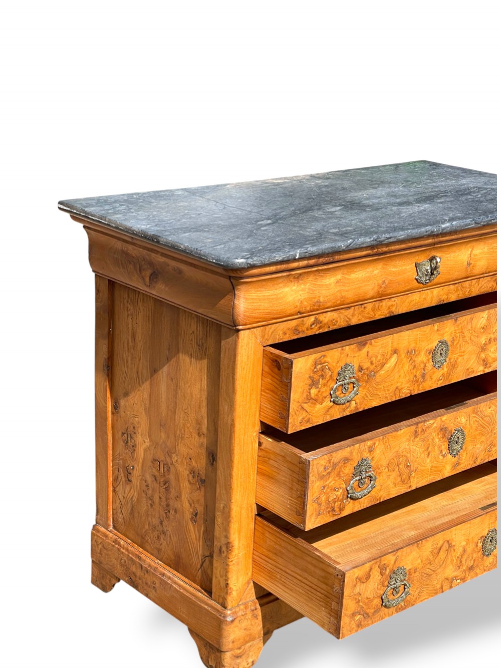 A French Louis Philippe style burr ash commode featuring a dark grey marble top, four drawers, and ornate brass handles. View XII