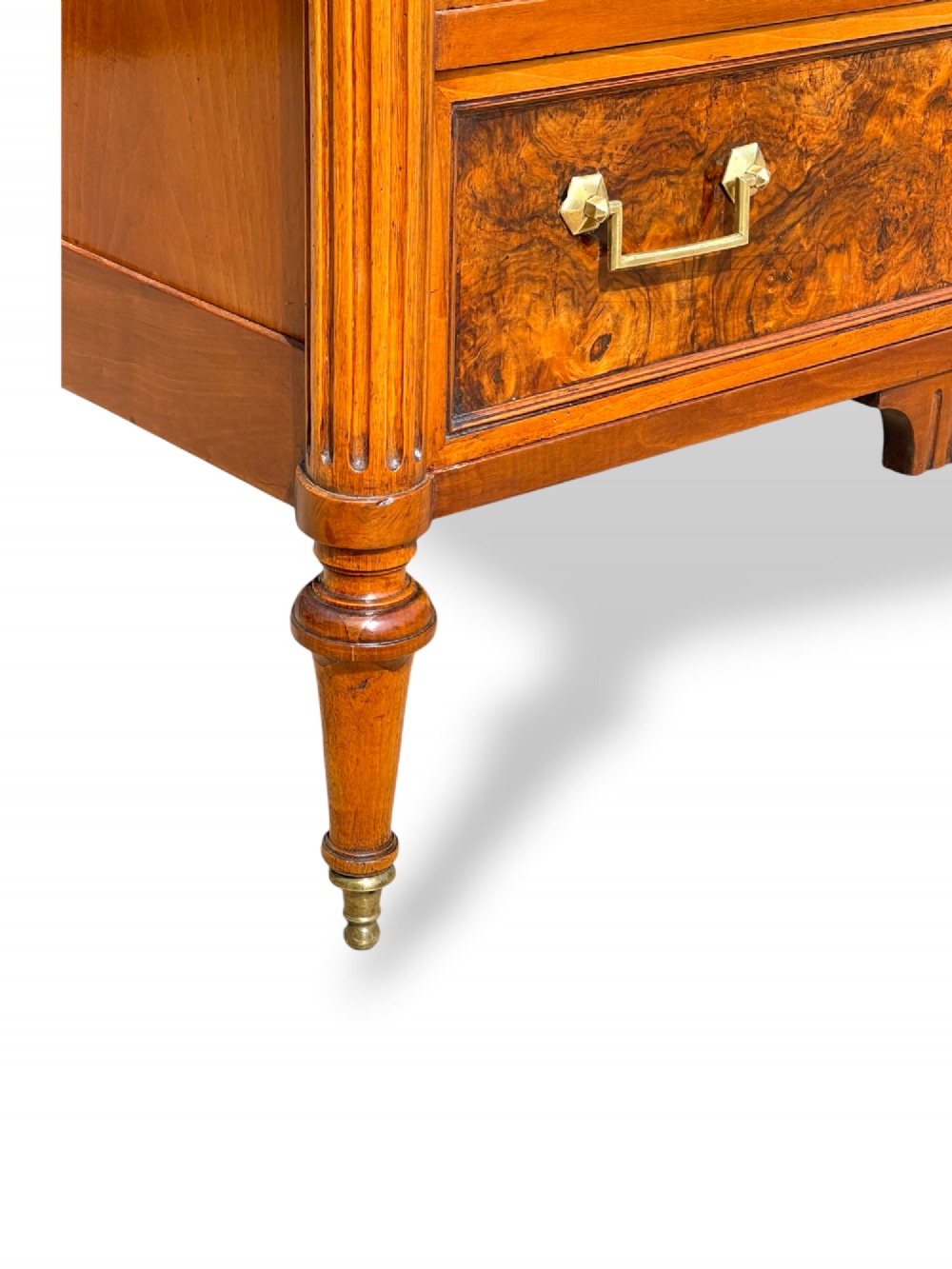 An eighteenth-century French walnut commode featuring figure-grained drawer fronts, brass handles, fluted corner pilasters, and tapered turned legs. View XI