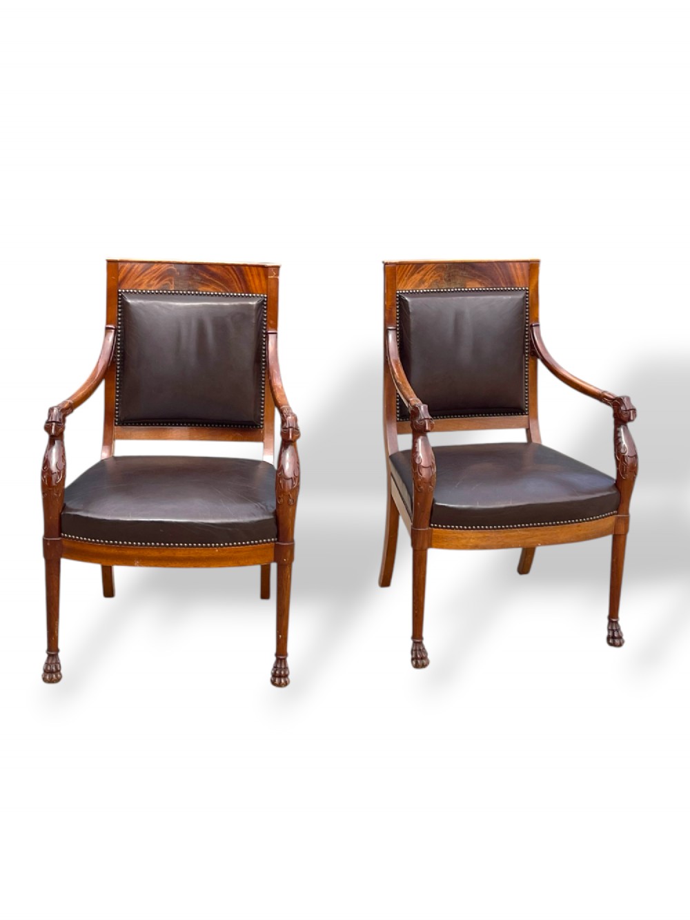 A pair of twentieth-century French Empire style armchairs featuring carved mahogany frames, dark brown leather upholstery, and brass stud trim. View III