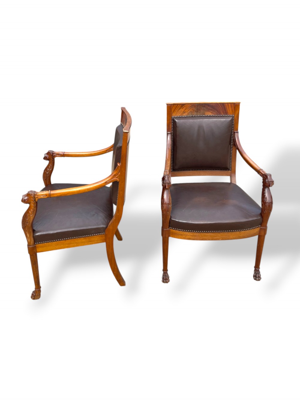 A pair of twentieth-century French Empire style armchairs featuring carved mahogany frames, dark brown leather upholstery, and brass stud trim. View VII
