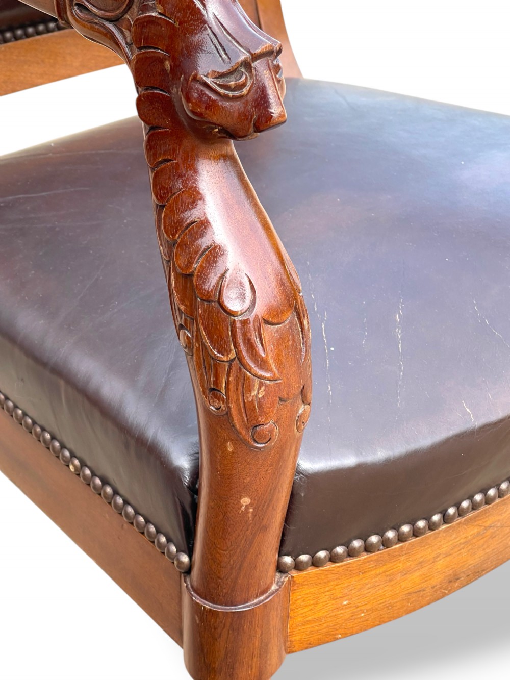 A pair of twentieth-century French Empire style armchairs featuring carved mahogany frames, dark brown leather upholstery, and brass stud trim. View VIII