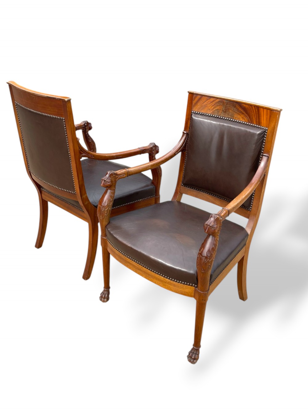 A pair of twentieth-century French Empire style armchairs featuring carved mahogany frames, dark brown leather upholstery, and brass stud trim. View XIII