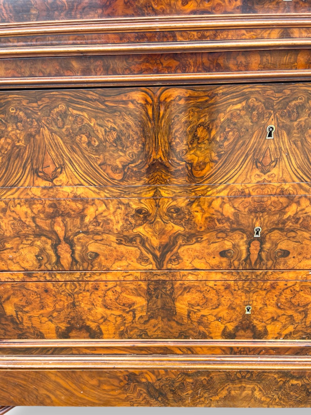 A 19th-century French Louis Philippe walnut commode featuring a grey marble top surface and figured walnut timber drawers with brass keyhole escutcheons. View II