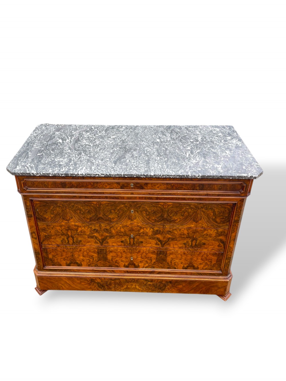 A 19th-century French Louis Philippe walnut commode featuring a grey marble top surface and figured walnut timber drawers with brass keyhole escutcheons. View V