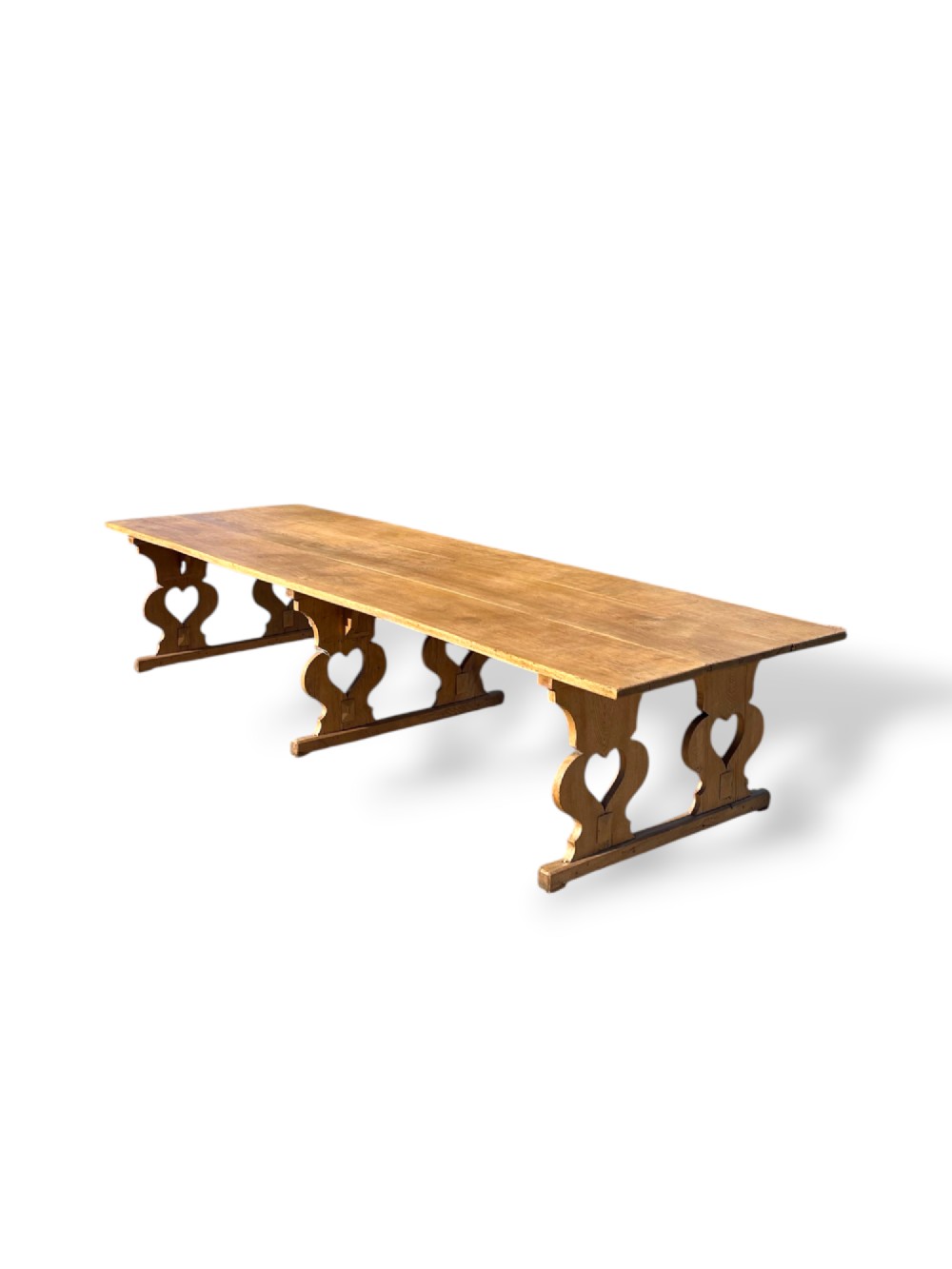 A large 19th-century English oak low coffee table featuring a three-plank top and trestle legs with heart-shaped cutouts connected by a central stretcher. View III