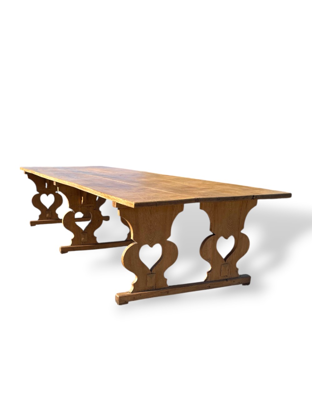 A large 19th-century English oak low coffee table featuring a three-plank top and trestle legs with heart-shaped cutouts connected by a central stretcher. View VIII