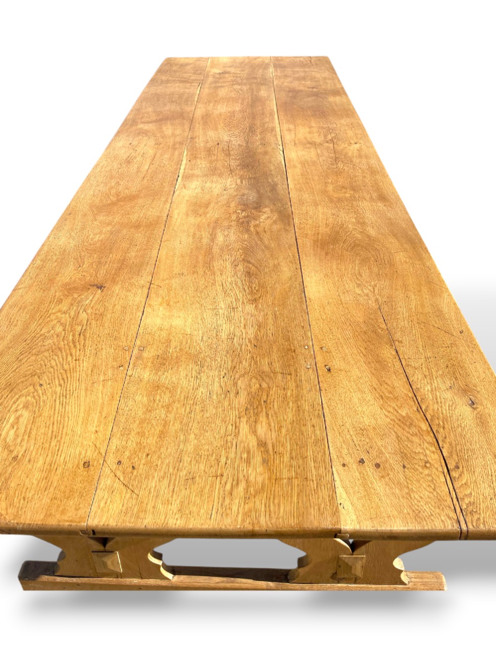A large 19th-century English oak low coffee table featuring a three-plank top and trestle legs with heart-shaped cutouts connected by a central stretcher. View XIV
