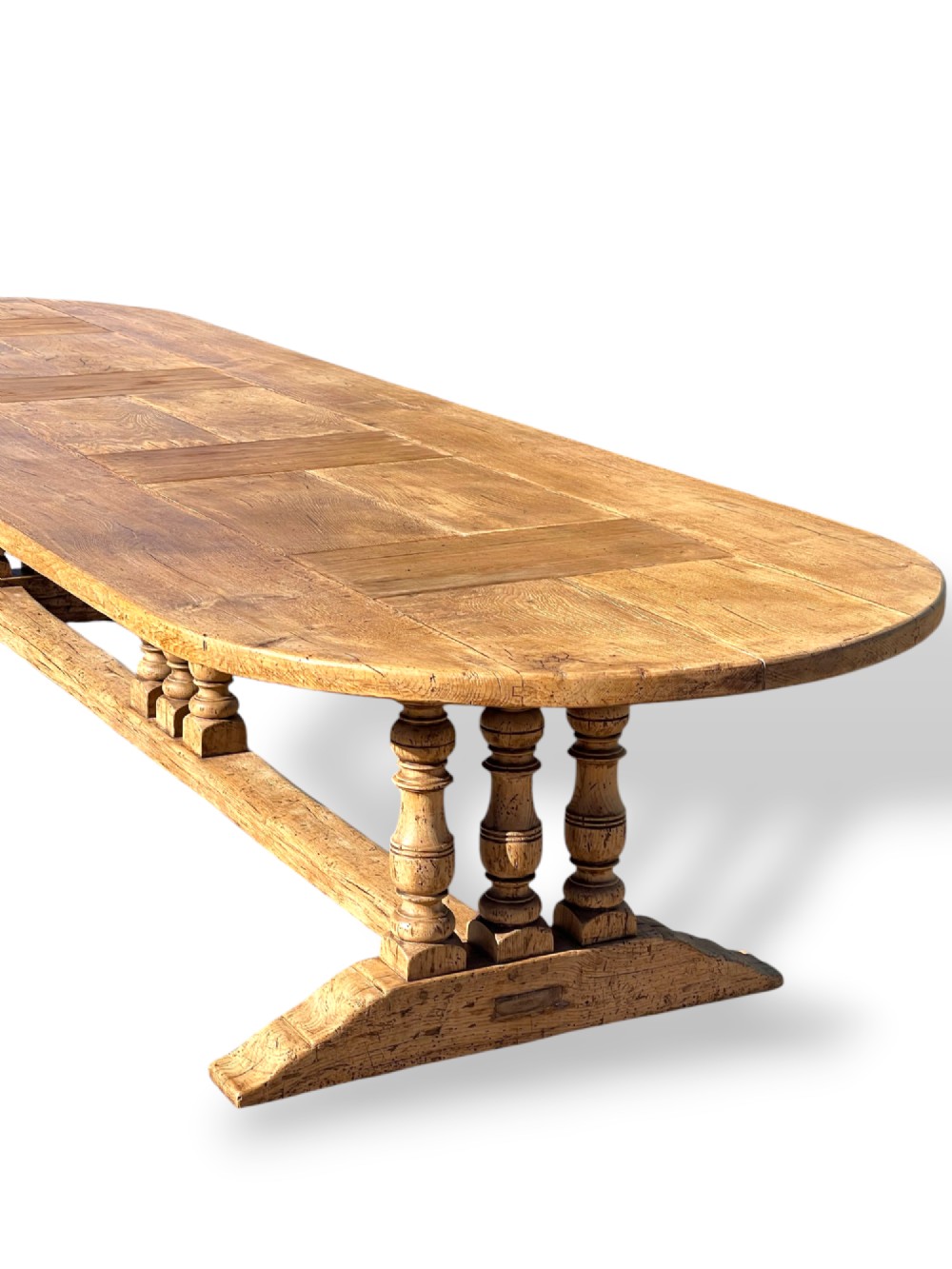 A four-metre French oak refectory dining table with rounded ends, a panelled timber top, and turned baluster legs set on trestle bases. View II